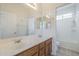 Bathroom features double sinks, wood cabinets, a shower over tub, and neutral walls at 16526 W Calle Lejos --, Surprise, AZ 85387