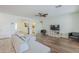 Open living room with wood-look floors features modern furnishings and seamless flow to entry hall and kitchen at 16526 W Calle Lejos --, Surprise, AZ 85387