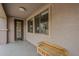 A covered patio featuring a wooden bench, neutral stucco and large window at 16526 W Calle Lejos --, Surprise, AZ 85387