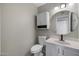 Powder room with white vanity, toilet, and decorative mirror with modern fixtures and sconce lighting at 1683 W Maplewood St, Chandler, AZ 85286