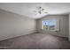 Large bedroom with neutral tones, carpet flooring, ceiling fan, and bright window at 1683 W Maplewood St, Chandler, AZ 85286