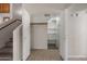 Hall closet with open doors, shelving, carpet and tile flooring on main level near staircase at 1683 W Maplewood St, Chandler, AZ 85286