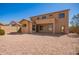 Exterior view of the home highlighting the back patio and spacious gravel backyard at 17458 W Wandering Creek Rd, Goodyear, AZ 85338