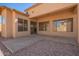 Covered patio leading to backyard area with desert landscaping and access to the house at 17458 W Wandering Creek Rd, Goodyear, AZ 85338