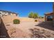 Large backyard with gravel landscaping, shrubs, and block wall for privacy at 17458 W Wandering Creek Rd, Goodyear, AZ 85338