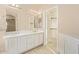 Bright bathroom with a double sink vanity, decorative lighting, and access to the walk-in closet at 17458 W Wandering Creek Rd, Goodyear, AZ 85338