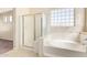 Bathroom featuring a soaking tub with tile surround and a separate shower with a glass enclosure at 17458 W Wandering Creek Rd, Goodyear, AZ 85338