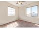 Bright bedroom with two windows letting in natural light and cozy carpet at 17458 W Wandering Creek Rd, Goodyear, AZ 85338