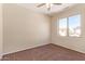 Standard bedroom with a ceiling fan, and a view of the neighboring houses through the window at 17458 W Wandering Creek Rd, Goodyear, AZ 85338