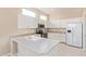 Well-lit kitchen with modern appliances, sink, and white cabinetry at 17458 W Wandering Creek Rd, Goodyear, AZ 85338