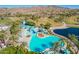 Aerial view of a resort-style pool with a water park, surrounded by palm trees and green lawns at 17458 W Wandering Creek Rd, Goodyear, AZ 85338