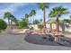 An expansive backyard features professional landscaping, palm trees, and a peaceful waterfall feature at 17806 N Becke Ln, Surprise, AZ 85374