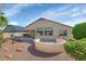 Attractive backyard featuring a covered patio, water feature, and lush green landscaping at 17806 N Becke Ln, Surprise, AZ 85374