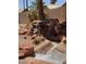 Beautiful backyard showcasing a rock waterfall feature and low-maintenance desert landscaping at 17806 N Becke Ln, Surprise, AZ 85374