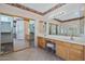 Bathroom featuring double sinks, vanity area, and a mirrored closet, offering practical space and storage solutions at 17806 N Becke Ln, Surprise, AZ 85374