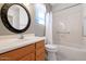 Bright bathroom featuring a vanity with wood cabinets and a shower-tub combo with white tile at 17806 N Becke Ln, Surprise, AZ 85374