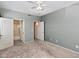 Empty bedroom showcasing neutral walls and plush carpeting, with multiple doorways leading to other rooms and bathrooms at 17806 N Becke Ln, Surprise, AZ 85374