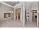 Open-concept hallway with arched entryways, neutral paint, tile flooring, and natural light at 17806 N Becke Ln, Surprise, AZ 85374