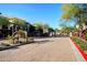 Community entrance with brick-paved road and meticulously maintained landscaping at 17850 N 68Th St # 1037, Phoenix, AZ 85054
