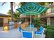Outdoor kitchen and dining area with stainless steel grill and seating under a colorful umbrella at 17850 N 68Th St # 1037, Phoenix, AZ 85054