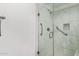 Elegant marble-tiled shower with glass doors, a handrail, and a built-in shower niche at 17850 N 68Th St # 1037, Phoenix, AZ 85054