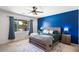 Bright bedroom with a wooden bed frame and an accent blue wall at 18237 W Port Au Prince Ln, Surprise, AZ 85388