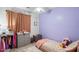 bedroom features a lavender accent wall and closet with colorful clothes at 18237 W Port Au Prince Ln, Surprise, AZ 85388