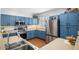Well-equipped kitchen with blue cabinetry, stainless steel appliances, and wood-look flooring at 18237 W Port Au Prince Ln, Surprise, AZ 85388