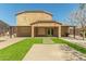 A backyard showing artificial turf, concrete pavers and patio, and the house's exterior at 18483 W Paradise Ln, Surprise, AZ 85388