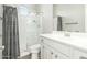 Clean bathroom featuring a glass enclosed shower with a grey curtain, white vanity and grey walls at 18483 W Paradise Ln, Surprise, AZ 85388