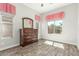 Bedroom featuring a dresser, hardwood floors and large windows with views of the exterior landscape at 18483 W Paradise Ln, Surprise, AZ 85388