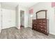 Bedroom featuring a dresser, hardwood floors and an ensuite bathroom with a tiled shower at 18483 W Paradise Ln, Surprise, AZ 85388