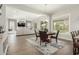 Open dining area with wood flooring and a view of the bright living room and modern fireplace at 18483 W Paradise Ln, Surprise, AZ 85388