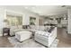 Open concept living room features a large sectional sofa, plenty of light, and backyard views at 18483 W Paradise Ln, Surprise, AZ 85388