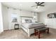 The primary suite features a ceiling fan, neutral carpet, and bright windows at 18483 W Paradise Ln, Surprise, AZ 85388
