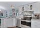 Well-lit kitchen featuring white cabinetry, stainless steel appliances, and modern fixtures at 201 S Greenfield Rd # 255, Mesa, AZ 85206