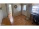 Bright home office space with wood-look floors, wreath on the wall, and view to bathroom, and an exterior door at 2072 W Klamath Ave, Apache Junction, AZ 85119