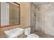 Well-lit bathroom featuring a sink, mirror, toilet, and a glass-enclosed shower with gray tiling at 2211 E Camelback Rd # 604, Phoenix, AZ 85016