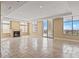 Expansive living room with a stone fireplace, balcony, and floor-to-ceiling windows with city views at 2211 E Camelback Rd # 604, Phoenix, AZ 85016