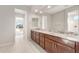 Bathroom featuring double vanity with granite countertops, dark wood cabinetry, and modern fixtures at 26930 W Renee Dr, Buckeye, AZ 85396