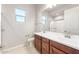 Well-lit bathroom with double sink vanity, framed mirror, and glass-enclosed shower at 26930 W Renee Dr, Buckeye, AZ 85396