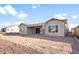 Exterior view of the back of a modern one-story home with a covered patio, large windows, and a dirt yard at 26942 W Renee Dr, Buckeye, AZ 85396