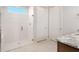 Modern bathroom featuring a glass shower with white tiled walls and floor, a rainfall shower head, and dual white doors at 26942 W Renee Dr, Buckeye, AZ 85396