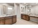 Bathroom with dual sink vanity with granite countertop and dark wood cabinetry, large mirror, and a tiled floor at 26942 W Renee Dr, Buckeye, AZ 85396