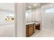 Bright bathroom featuring double sinks, a glass-enclosed shower, and modern fixtures at 26942 W Renee Dr, Buckeye, AZ 85396