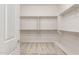 A spacious walk-in closet with white shelving and carpeted floor, offering ample storage space at 26942 W Renee Dr, Buckeye, AZ 85396