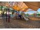Community playground featuring slides, climbing structures, and swings under a large sunshade at 2717 W Medina Ave, Mesa, AZ 85202