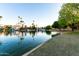 Scenic waterfront view with palm trees, lush landscaping, and boats, offering a peaceful setting for lakeside living at 2717 W Medina Ave, Mesa, AZ 85202