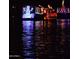 Festive holiday boat parade reflecting colorful lights on the water at night at 2717 W Medina Ave, Mesa, AZ 85202
