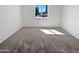 Empty bedroom showing clean, neutral carpet and walls, with a bright window at 3702 E Karen Dr, Phoenix, AZ 85032